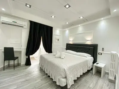 a white bedroom with a bed and a desk at Locanda Parlamento in Rome