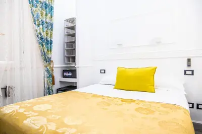 a bedroom with a yellow pillow on a bed at Locanda Parlamento in Rome