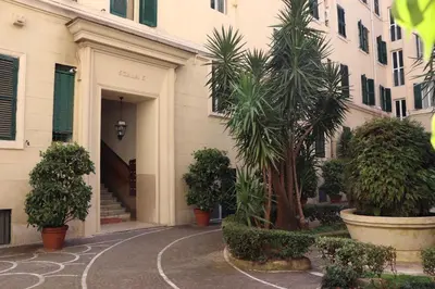 a building with palm trees in a courtyard at The Center Of Rome B&B in Rome