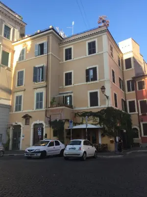 two cars parked in front of a large building at Livia B&B - Trastevere in Rome