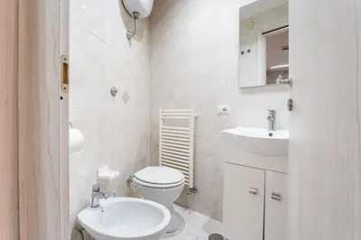 a white bathroom with a toilet and a sink at FL Apartments Il piccolo borgo di Trastevere in Rome