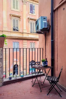 a table and chairs on a balcony with a tv at FL Apartments Il piccolo borgo di Trastevere in Rome