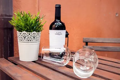 a bottle of wine and a plant on a wooden table at FL Apartments Il piccolo borgo di Trastevere in Rome