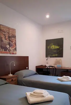 a hotel room with two beds and a tv at L'Oasi al Pigneto - Guest house in Rome