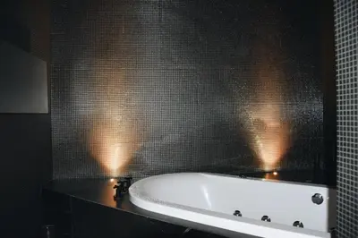 a bathroom with a tub and a tiled wall at LuMa Suite Via Veneto - Your luxury style 29 in Rome