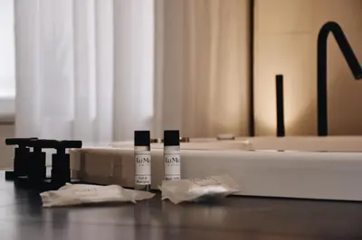 two bottles ofodorizers sitting on a counter next to a bath tub at LuMa Suite Via Veneto - Your luxury style 29 in Rome