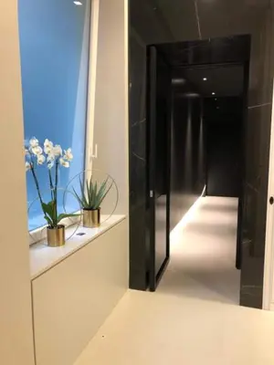a hallway with a black door and a vase of flowers at LuMa Suite Via Veneto - Your luxury style 29 in Rome