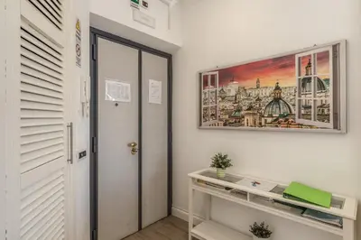 a hallway with a desk and a painting on the wall at Domus Heroas near Vatican in Rome
