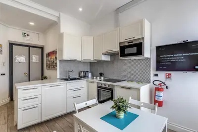 a kitchen with white cabinets and a table and chairs at Domus Heroas near Vatican in Rome
