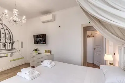a white bedroom with two towels on a bed at Domus Heroas near Vatican in Rome