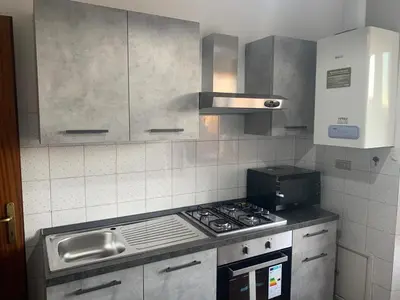a kitchen with a stove top oven and a sink at Arion Holiday Home in Rome