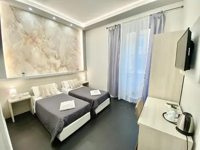 a hotel room with two beds and a television at Residenza Giustiniani in Rome