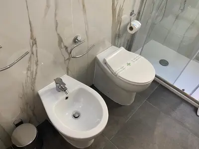 a white bathroom with a toilet and a sink at Residenza Giustiniani in Rome