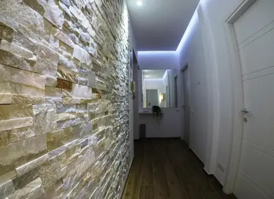 a hallway with a brick wall and a door at Poliziano Apartment in Rome