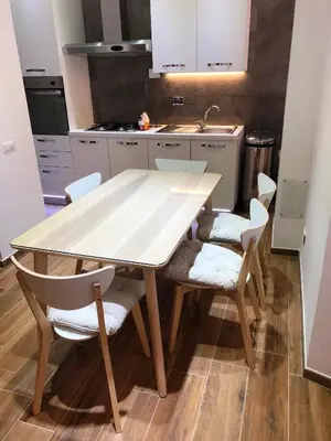 a kitchen with a wooden table and chairs at Poliziano Apartment in Rome