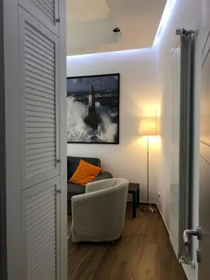 a living room with a couch and a picture of a lighthouse at Poliziano Apartment in Rome
