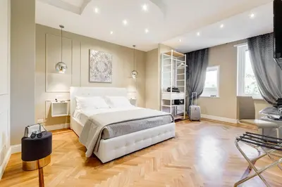 a bedroom with a large white bed and wooden floors at Mellini Palace Suites by Premium Suites Collection in Rome
