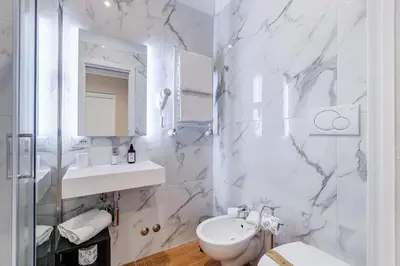 a white bathroom with a sink and a mirror at Mellini Palace Suites by Premium Suites Collection in Rome