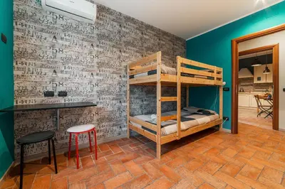 a bedroom with bunk beds and a brick wall at B&B Papa Leone Countryrooms in Rome