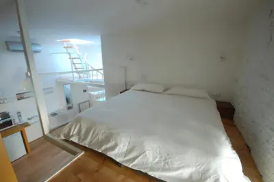 a white bed in a room with a staircase at LOST&FOUND in Trastevere in Rome