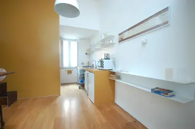 a kitchen with yellow and white walls and wooden floors at LOST&FOUND in Trastevere in Rome