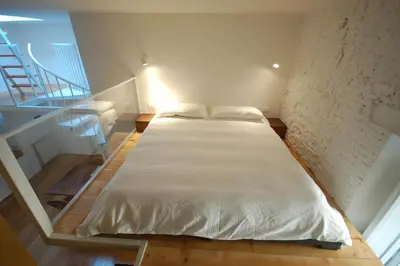a white bed in a room with a staircase at LOST&FOUND in Trastevere in Rome
