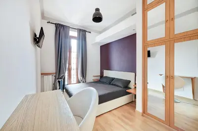 a bedroom with a bed and a table and a window at Peroni 8 Pax Brand New Apartment in Rome