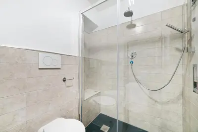 a bathroom with a glass shower with a toilet at Peroni 8 Pax Brand New Apartment in Rome