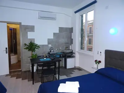 a room with a bed and a table and a kitchen at Harmony & Comfort at the Vatican Museum in Rome