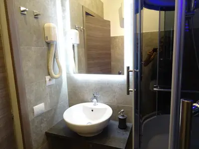a person taking a picture of a bathroom with a sink at Harmony & Comfort at the Vatican Museum in Rome