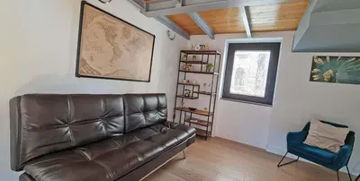 a living room with a leather couch and a blue chair at Ponte Milvio Luxury House in Rome