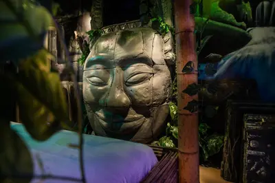 a statue of a face is sitting next to a bed at MagicSuite Guest House Roma Portuense in Rome