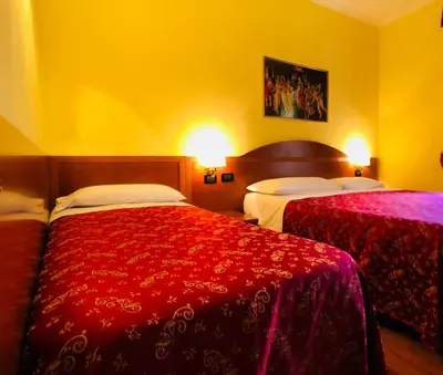 a hotel room with two beds with red sheets at Saint Peter Inn in Rome