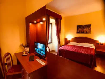 a bedroom with a bed and a desk with a computer at Saint Peter Inn in Rome
