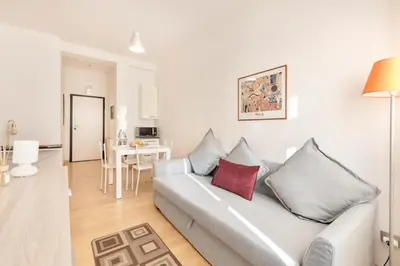 a white living room with a couch and a table at World Wide Bed San Giovanni in Rome
