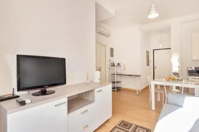 a white living room with a flat screen tv on a counter at World Wide Bed San Giovanni in Rome