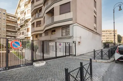 a fence in front of a building with a sign at World Wide Bed San Giovanni in Rome