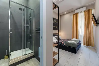 a bathroom with a shower and a bed in a room at Empire Suites in Rome