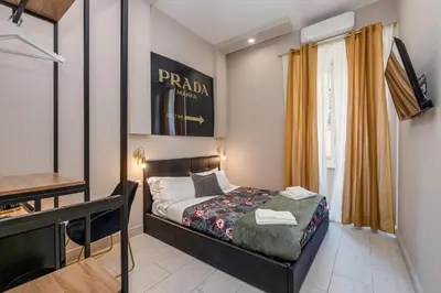 a small bedroom with a bed and a desk at Empire Suites in Rome