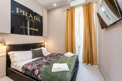 a bedroom with a bed and a window with orange curtains at Empire Suites in Rome