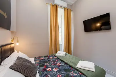 a bedroom with a bed and a tv on the wall at Empire Suites in Rome