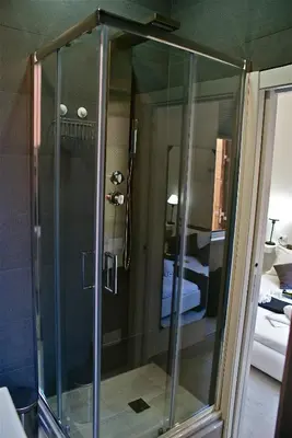 a shower stall with a glass door in a room at Empire Suites in Rome