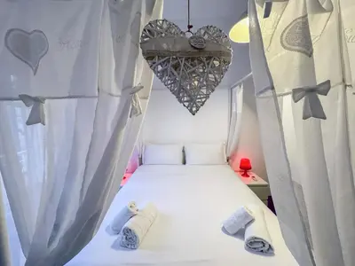 a bed in a room with a heart hanging above it at JHHIT San Pietro Modern Suite in Rome