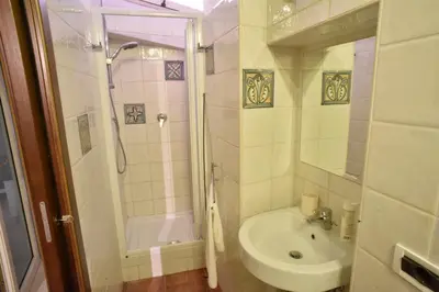 a white bathroom with a sink and a shower at Urbana Colosseo Boutique Apartment in Rome