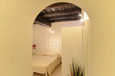 a bedroom with a bed and an archway at Urbana Colosseo Boutique Apartment in Rome