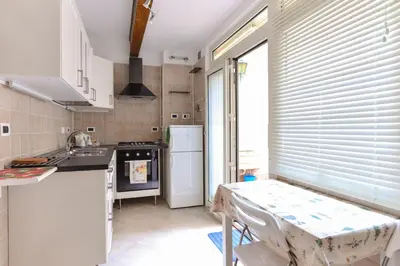 a kitchen with a table and a white refrigerator at Urbana Colosseo Boutique Apartment in Rome