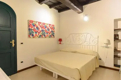 a bedroom with a bed and a painting on the wall at Urbana Colosseo Boutique Apartment in Rome