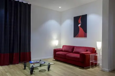 a living room with a red couch and a table at Dimoro Suite in Rome