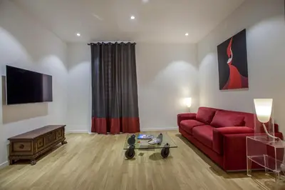a living room with a red couch and a table at Dimoro Suite in Rome