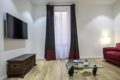 a living room with a red couch and a glass table at Dimoro Suite in Rome